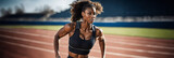 Atleta negra correndo na pista de corrida durante o dia. Mulher corredora negra treinando e se aquecendo dentro de um estádio.