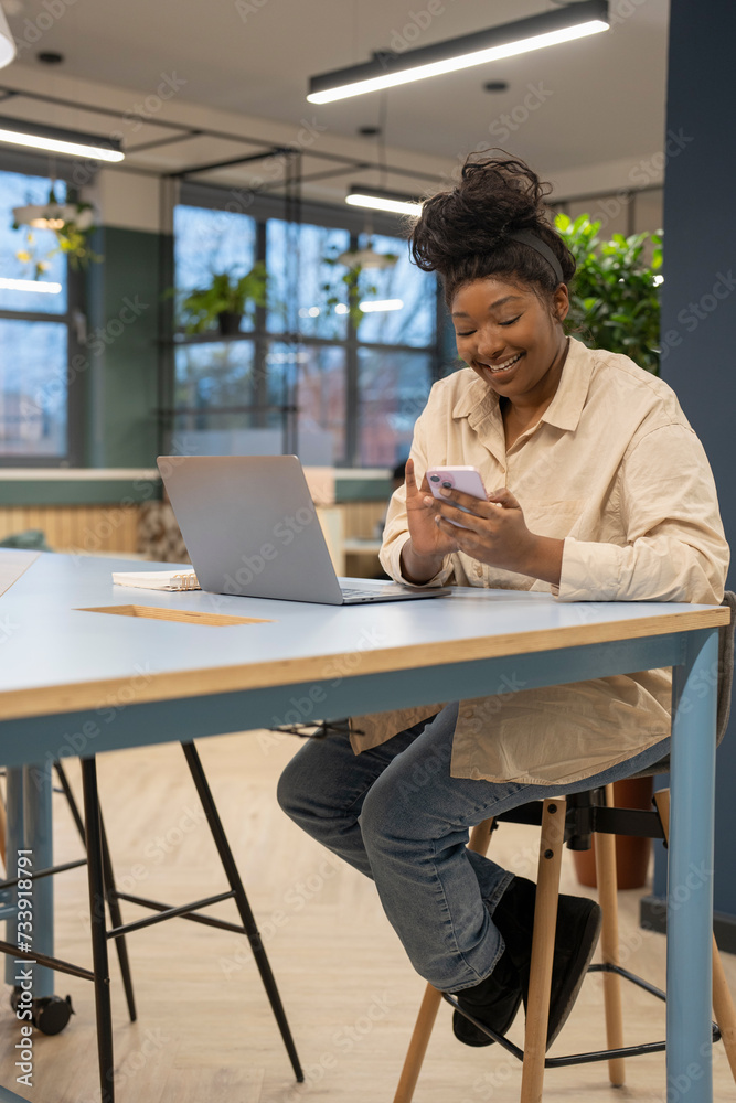 Businesswoman using phone and laptop in office Businesswoman using phone and laptop in office