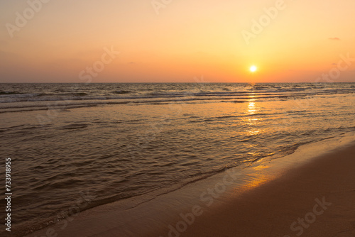 Sunset over the beachy sea with a beautiful orange-red twilight, and reflections in the water. Sea beach with sunrise or sunset, seascape, Landscape © natthapol