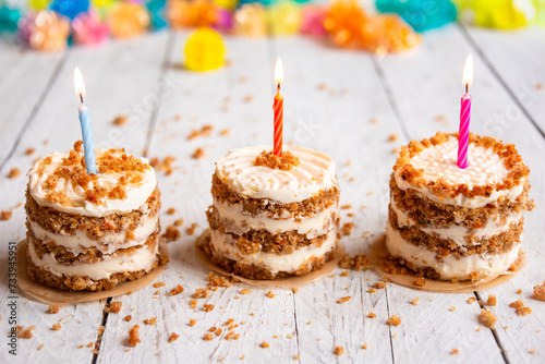 Small cakes with candles on white background