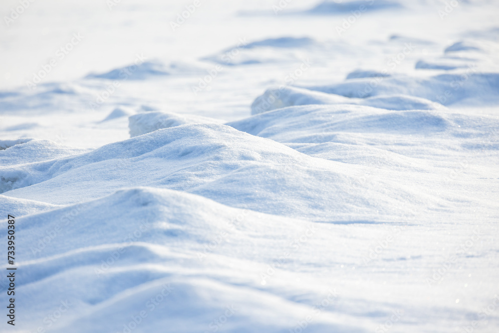 Wavy snowdrift surface on a sunny day, natural background