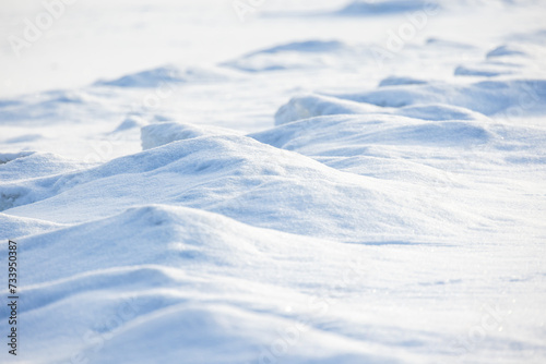 Wavy snowdrift surface on a sunny day, natural background