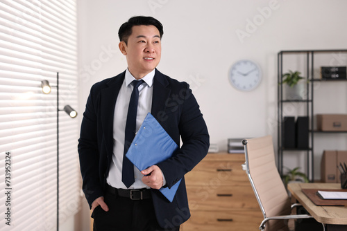 Portrait of happy notary with clipboard in office, space for text