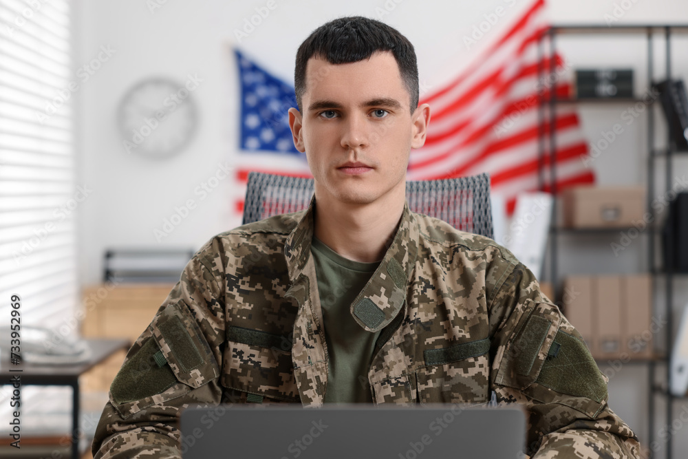 Military service. Young soldier working in office
