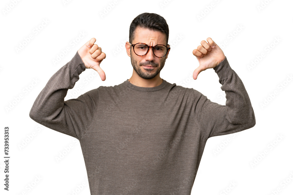 Young handsome caucasian man over isolated background showing thumb down with two hands Young handsome caucasian man over isolated background showing thumb down with two hands