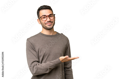Cuadro en lienzo Young handsome caucasian man over isolated background presenting an idea while l