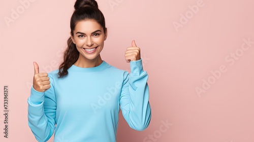 Young strong sporty athletic fitness trainer instructor woman wear blue tracksuit spend time in home gym show thumb up gesture blink isolated on pastel plain pink background. Workout sport concept. photo