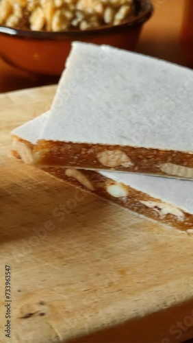 Cut pieces of Alajú on a wooden board, a variety of nougat traditional from the regions of Cuenca and Rincón de Ademuz in Spain, made with nuts, honey and breadcrumbs photo