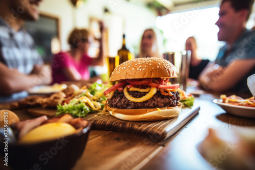 People enjoying a delicious meal, burgers, onion rings and french fries while dining out