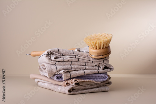 Eco wooden dish brush and stack of linen and cotton napkins photo