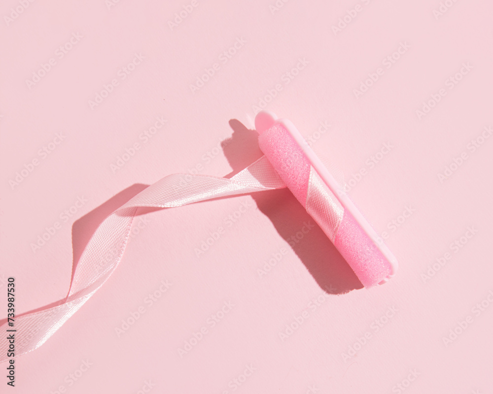 Sponge hair curler, wavy satin ribbon, creative pastel pink layout, hair care and styling. Sponge hair curler, wavy satin ribbon, creative pastel pink layout, hair care and styling.
