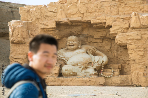 Silk Road Heritage City, Dunhuang City, Gansu Province - People standing in front of Buddha statues photo