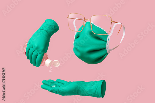 hand holding a bottle of hand sanitizer whit gloves and a mask (ID: 734005967)