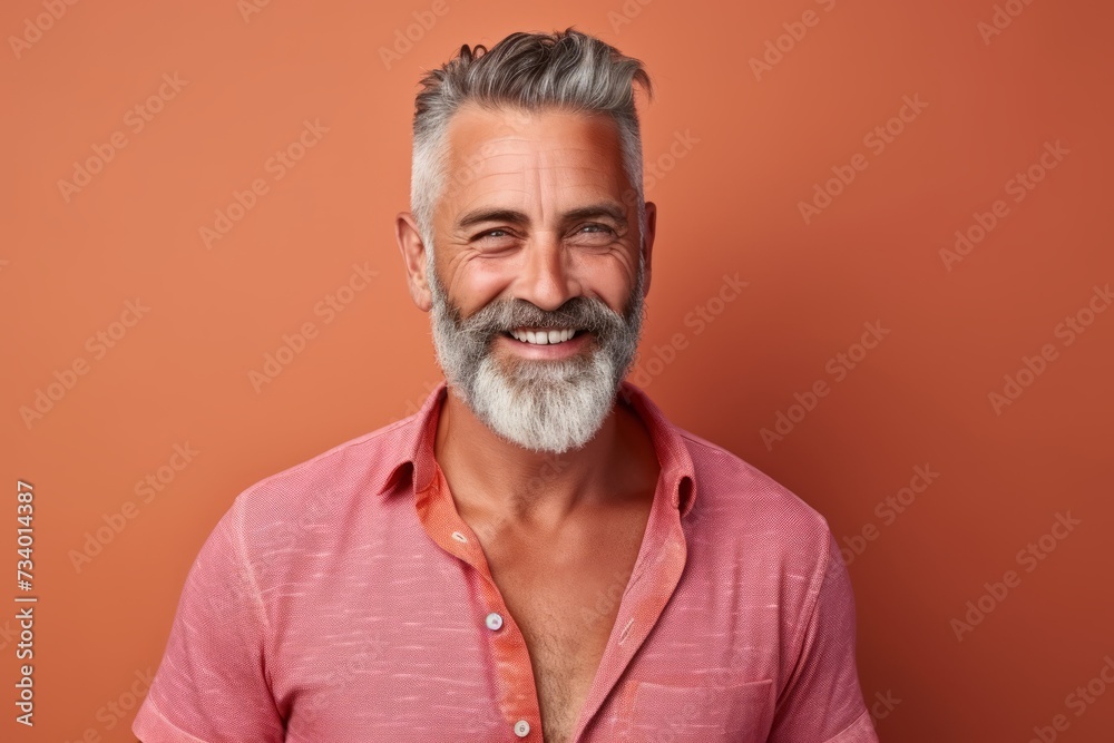 Portrait of smiling mature man with gray beard and mustache, isolated on orange background Portrait of smiling mature man with gray beard and mustache, isolated on orange background