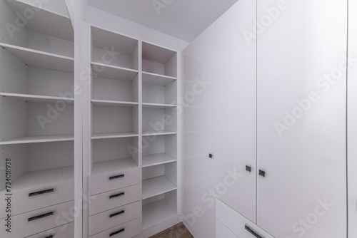 Empty wardrobe in dressing room. Wardrobe room, with empty shelves. Interior of modern empty dressing room, wardrobe.