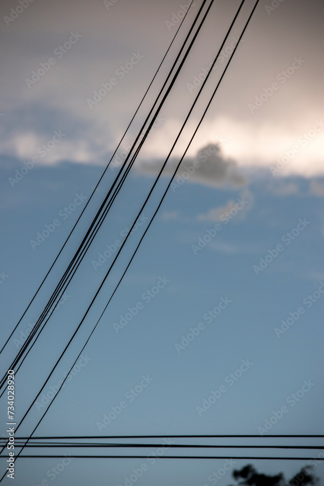 Fototapeta premium cable de electricidad sobre un cielo celeste con nubes