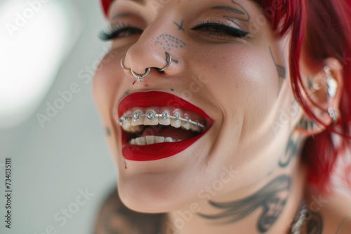 Tattooed woman with silver dental grillz and red lipstick photo