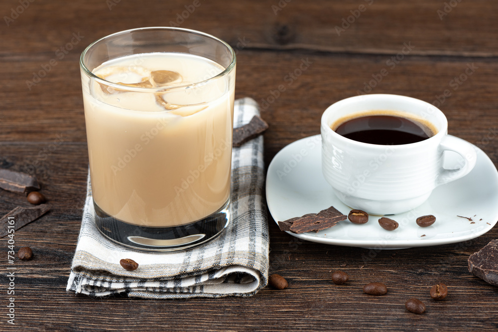 A cup of coffee and a glass of original Irish cream liqueur in a glass with ice. A cup of coffee and a glass of original Irish cream liqueur in a glass with ice.