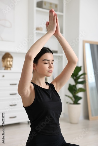 Portrait of beautiful girl practicing yoga at home