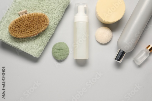 Bath accessories. Flat lay composition with personal care products on light grey background, space for text
