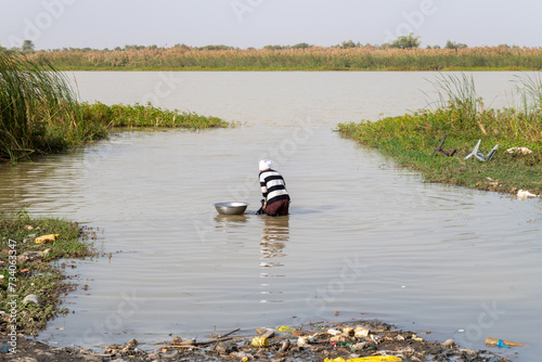 une femme fait la lessive dans la rivière au Sénégal en Afrique photo