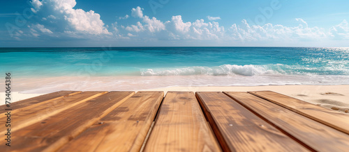 Empty wooden table or deck overlooking vast sandy beach and turquoise sea or ocean water. Copy space mockup 