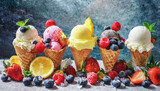 Ice cream assortment. Selection of colorful ice cream in waffle cones with berries and fruits in front of rustic background