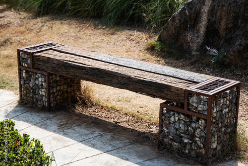 Wooden park benches are made from logs and stones.