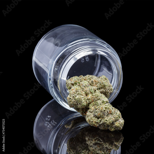 Cannabis in glass jar on black background