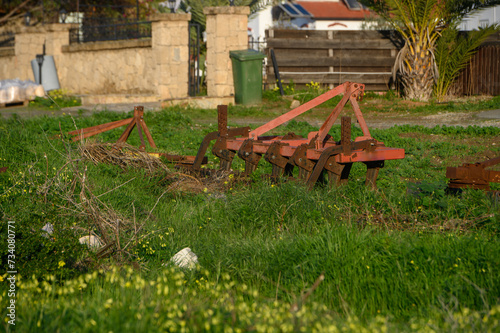 old agricultural machinery lying near a house in the village 1