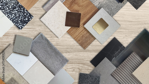 interior material samples contains panels and tiles. stylish interior moodboard including terrazzo, quartz, stone tiles, blue laminated, wooden flooring tiles, gold stainless placed on wooden table. photo