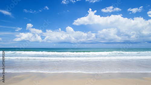 Beautiful beach with gentle waves and a bright blue sky filled with white clouds. Ideal for travel and nature projects.