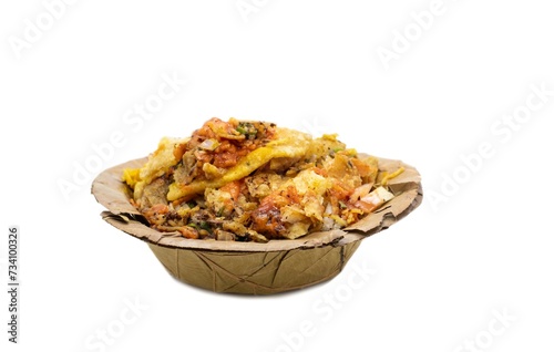 Closeup of Papri Chat or Papri Chaat Garnished with Chili, Onion Cuts, Tomato Sauce and Spices in a Dry Leaves Disposable Bowl Isolated on White Background with Copy Space, Indian Street Food