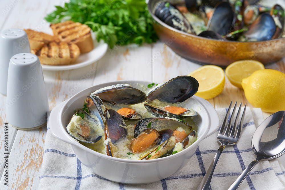 Delicious mediterranean seafood soup with mussels and prawns on a white table.