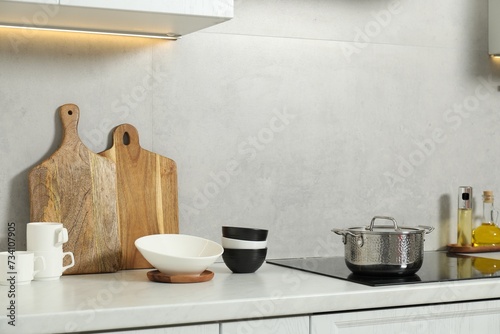Wooden cutting boards and other cooking utensils on white countertop in kitchen