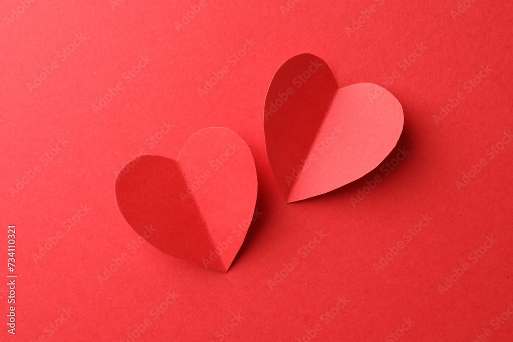 Paper hearts on red background, flat lay Paper hearts on red background, flat lay