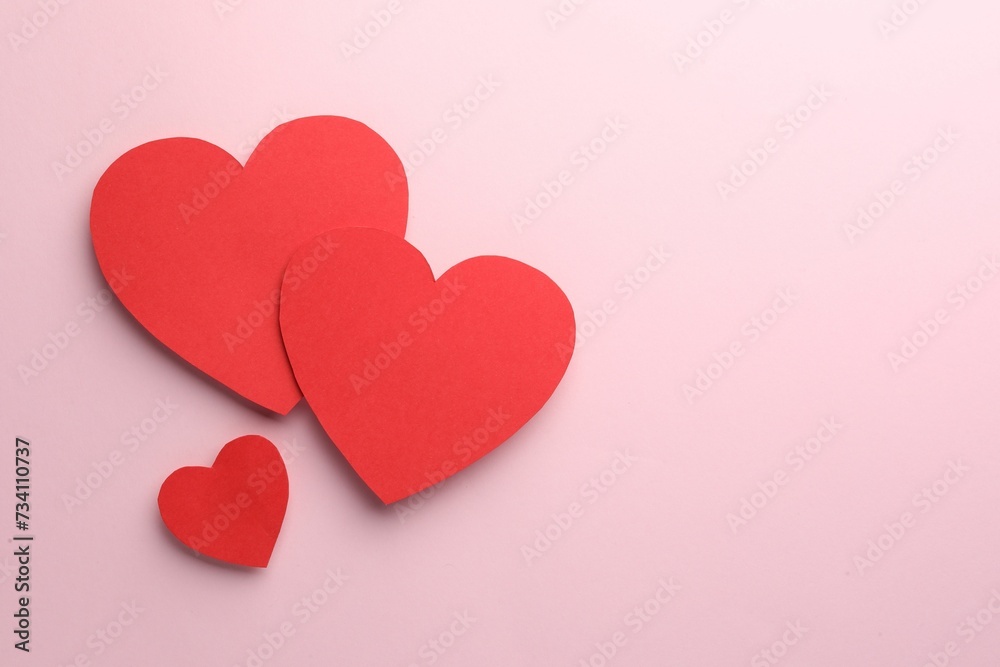 Paper hearts on pink background, flat lay. Space for text Paper hearts on pink background, flat lay. Space for text
