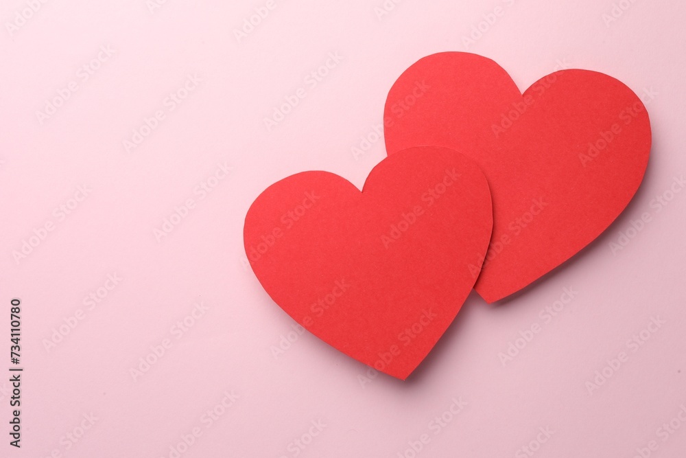 Paper hearts on pink background, top view. Space for text