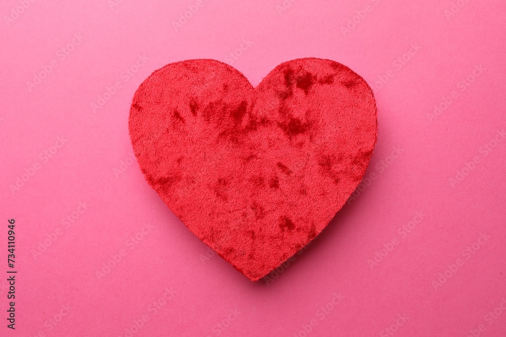 Red textile heart on pink background, top view Red textile heart on pink background, top view