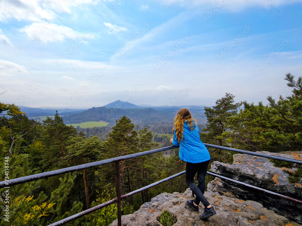 Girl admires the mountain view during a break from climbing, hiking trip