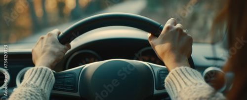 Woman driving a car with her hands on the steering wheel. Suitable for automotive or transportation-related content