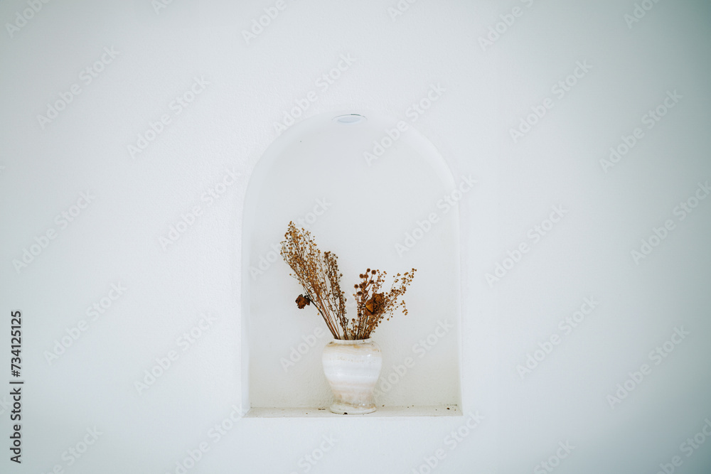 Dried Flowers in a white vase in an alcove Dried Flowers in a white vase in an alcove