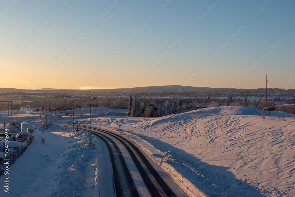 Winter road through the forest in Kiruna, Swedish Lapland. Northern Scandinavia.