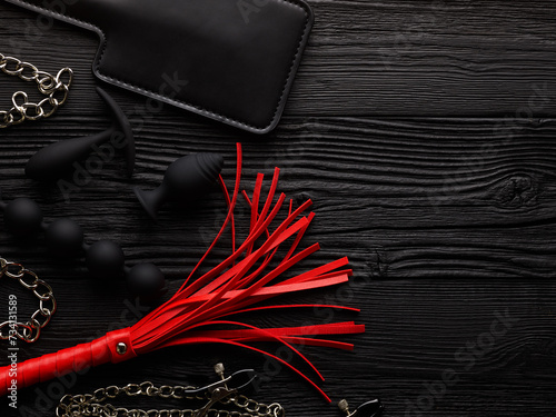 Set of BDSM toys over black wooden background photo