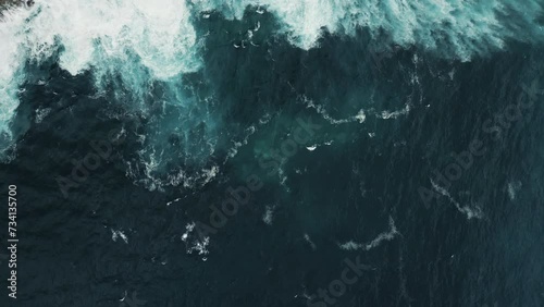 Aerial View of Ocean Waves Breaking on Rocky Shoreline. Drone Filming Foamy Ocean Waves and Rocky Coastline. Nusa Penida, Indonesia. Big Swells in Bali. Traveling Concept photo