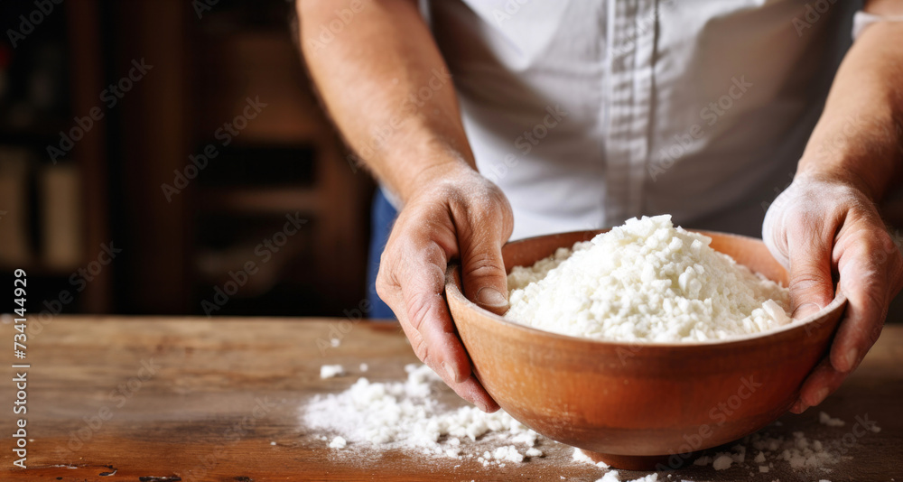 Man's hands kneading dough in a wooden bowl, closeup Man's hands kneading dough in a wooden bowl, closeup