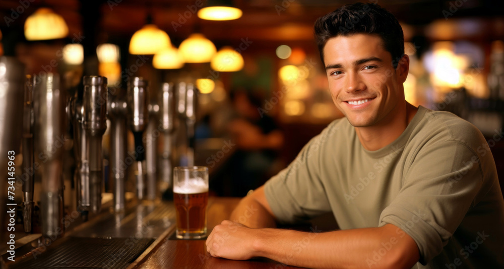 Handsome young man sitting at the bar counter and smiling.