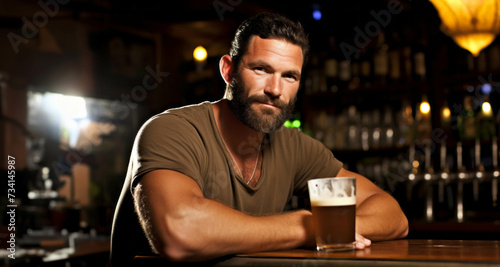 young handsome man drinking beer at bar or pub. Portrait of handsome caucasian hipster drinking beer.