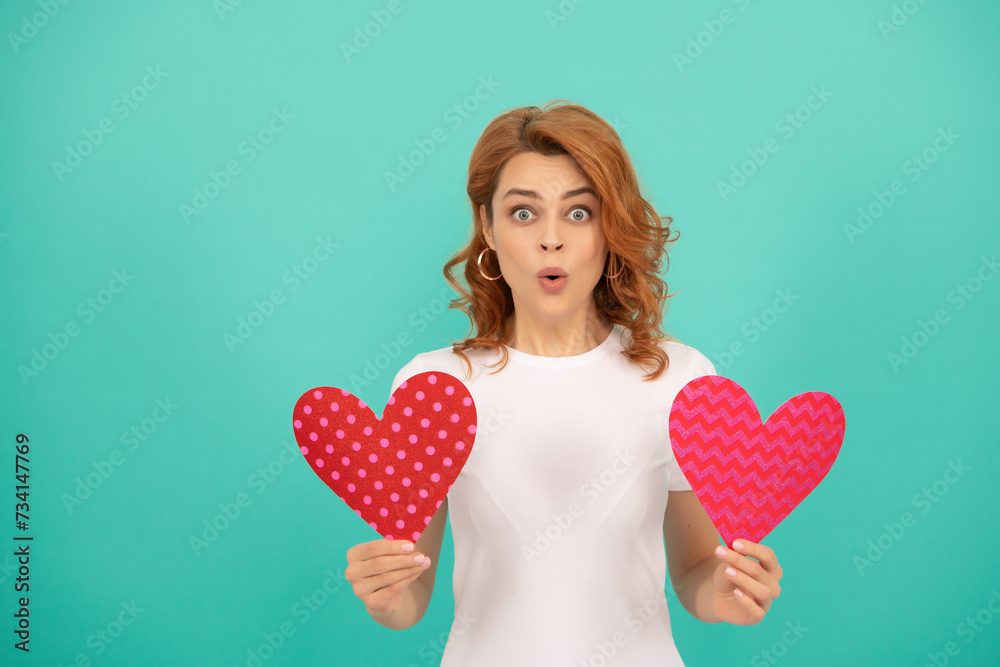 surprised young girl with red heart on blue background surprised young girl with red heart on blue background