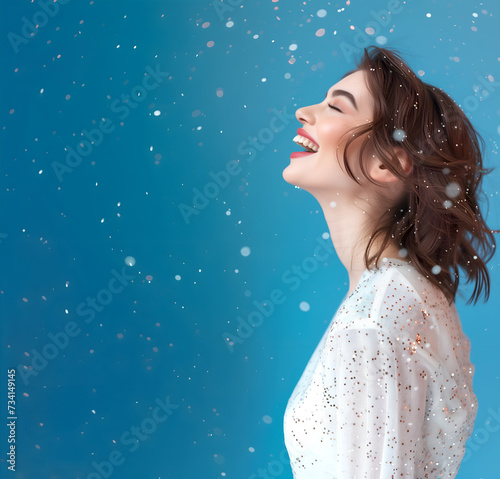Fashion editorial Concept. Happy laughing woman with falling sprinkles flakes on pastel blue background . soft colour setting . copy text space